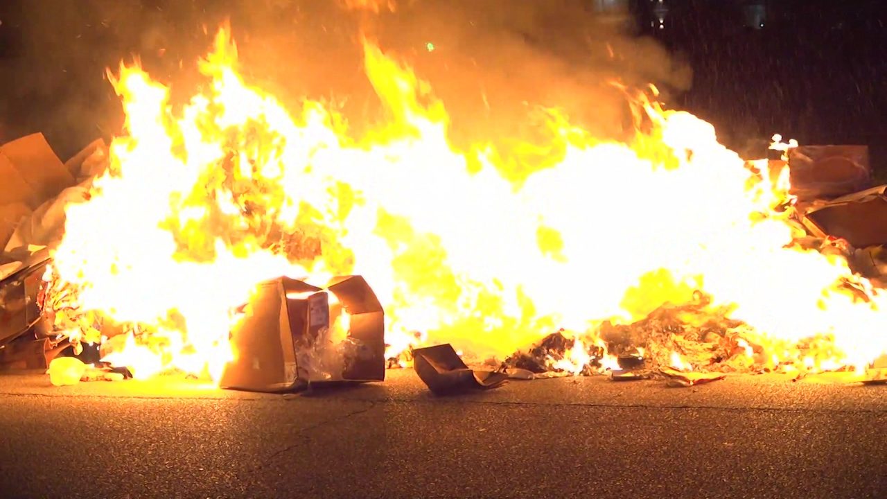 Burning trash forces garbage truck to dump contents onto street